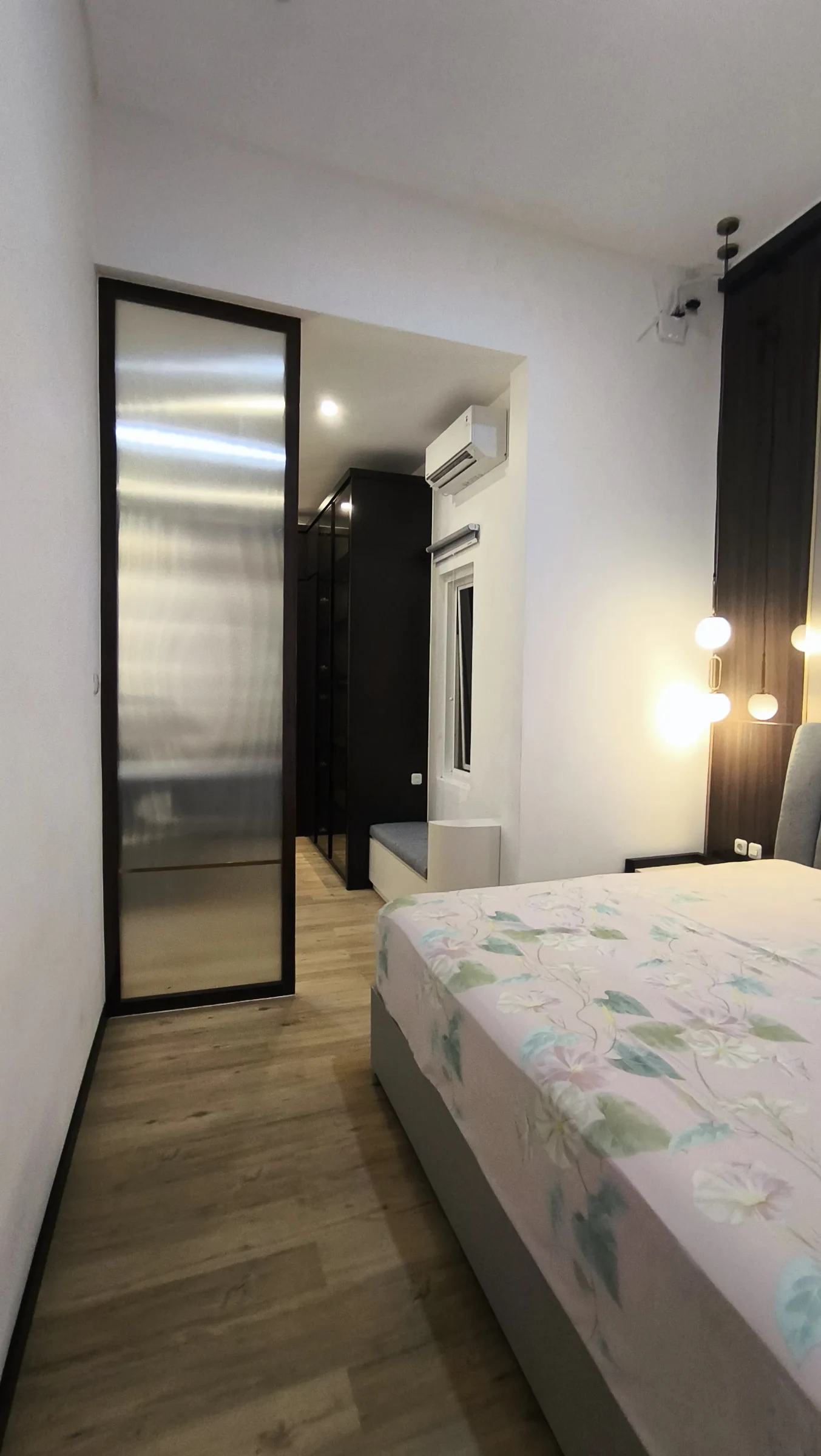 Lorong kamar utama dengan pintu kaca dan tempat tidur di sisi dalam